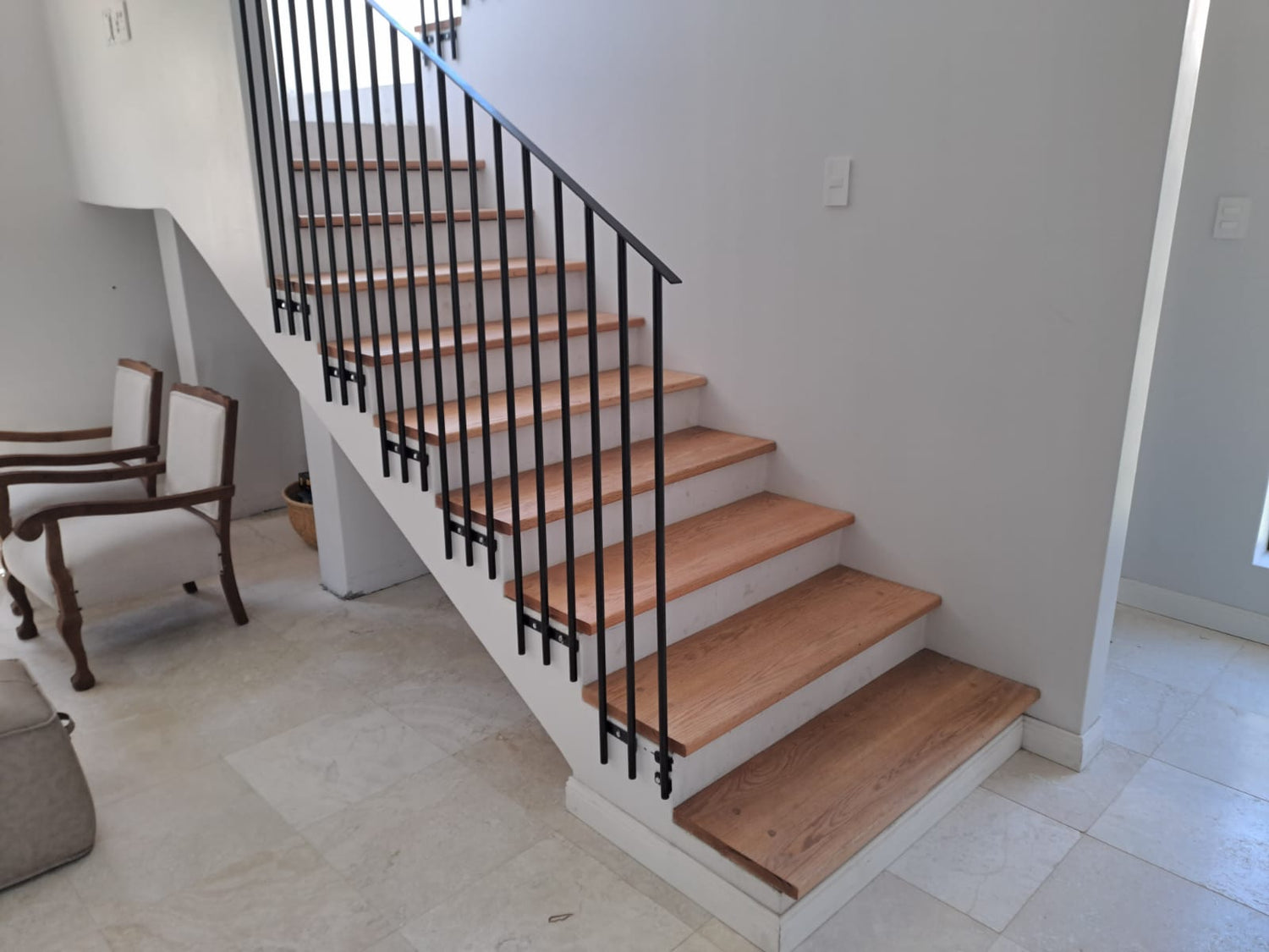 Wooden staircase with black railing in a home interior.