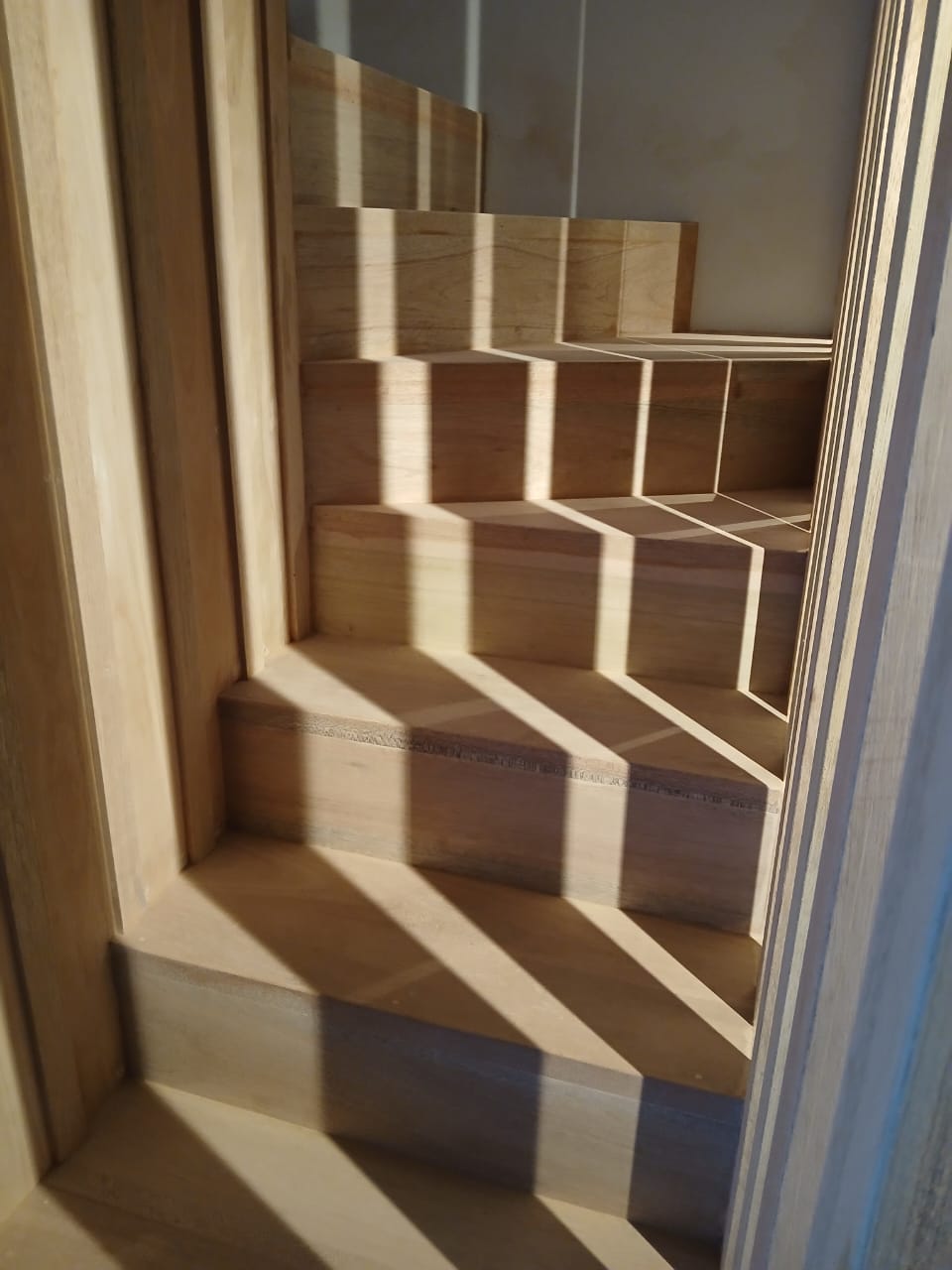 Wooden staircase with a geometric design in a room.